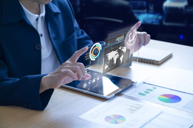 Business man or analyst expanding futuristic investment virtual screen over a modern tablet. Showing if charts and infographic for investment analysis.